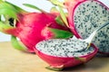 Eating dragon fruit pitaya and spoon on wooden background Royalty Free Stock Photo