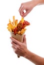 Male hand is taking a French frie from paper cone wrapper