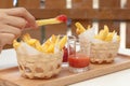 Eating french fries dipping with ketchup and chili sauce