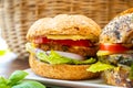 Eating of fresh and healthy vegetarian hamburgers with grilled spinach or pumpkin burgers, organic buns and vegetables Royalty Free Stock Photo