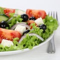 Eating Greek salad in bowl with tomatoes, Feta cheese, olives an Royalty Free Stock Photo