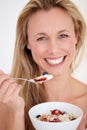 Eating healthily keeps her young. Beautiful woman smiling happily while enjoying a healthy bowl of breakfast. Royalty Free Stock Photo