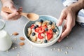 Eating healthy breakfast oatmeal porridge with fresh berries and nuts