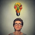 Eating healthy idea and diet tips concept. woman looking up light bulb made of fruits above head Royalty Free Stock Photo