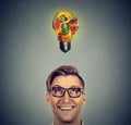 Eating healthy. Man looking up light bulb made of fruits Royalty Free Stock Photo
