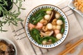 Eating homemade red and white small tangyuan with savory soup and vegetable