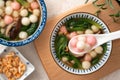 Eating homemade red and white small tangyuan with savory soup and vegetable