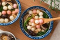 Eating homemade red and white small tangyuan with savory soup and vegetable