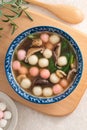 Eating homemade red and white small tangyuan with savory soup and vegetable