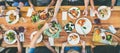 Eating and leisure concept - group of people having dinner at table with food