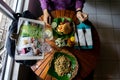 Eating an organic healthy food on the wooden round table. There are spaghetti with black pepper serving on the green banana leaf