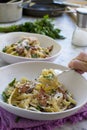 Eating pasta carbonara with a fork from a white bowl - white marble background Royalty Free Stock Photo