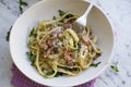 Eating pasta carbonara in a white bowl with a fork. Landscape. Royalty Free Stock Photo