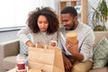 Happy couple with takeaway food and drinks at home Royalty Free Stock Photo