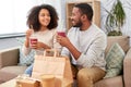 Happy couple with takeaway food and drinks at home Royalty Free Stock Photo