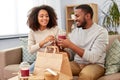 Happy couple with takeaway food and drinks at home Royalty Free Stock Photo