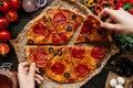 Eating pizza, top view. Hands taking slices of hot delicious pizza. Pizza ingredients on the wooden table Royalty Free Stock Photo