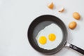 Eating in the process, fried eggs in a frying pan for breakfast on a white background. Daylight Royalty Free Stock Photo