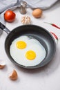 Eating in the process, fried eggs in a frying pan for breakfast on a white background. Daylight Royalty Free Stock Photo