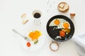 Eating in the process, fried eggs in a frying pan and on a plate, toast with avocado and a cup of coffee for breakfast. Royalty Free Stock Photo