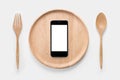 Eating smartphone on set of fork,spoon and dish wood isolated. Royalty Free Stock Photo