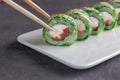 Eating Sushi with chopsticks.Closeup Sushi roll japanese food in restaurant Royalty Free Stock Photo