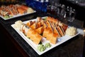 Eating sushi rolls. Japanese food restaurant, sushi maki gunkan roll plate or platter set. Closeup of hand with chopsticks taking Royalty Free Stock Photo