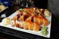 Eating sushi rolls. Japanese food restaurant, sushi maki gunkan roll plate or platter set. Closeup of hand with chopsticks taking Royalty Free Stock Photo