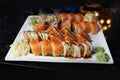 Eating sushi rolls. Japanese food restaurant, sushi maki gunkan roll plate or platter set. Closeup of hand with chopsticks taking Royalty Free Stock Photo