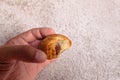 Eating a tiny chocolate croissant pastry with left hand