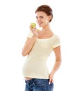 Eating for two now...A pretty pregnant woman holding a green apple while isolated on a white background. Royalty Free Stock Photo