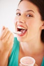 Eating, yogurt and portrait of woman with healthy food, diet or nutrition in studio with happiness. Happy, face and girl