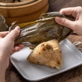 Eating zongzi - Dragon Boat Festival Rice dumpling young Asian woman eating Chinese traditional food on wooden table at home Royalty Free Stock Photo