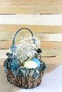 Eatser image includes a green, wire basket with colorful spotted eggs and baby`s breath on a wooden background.
