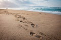 Eautiful beach with footprints in the sand. Couple of lovers walking on the beach at sunset and leaving foot prints on the beach.