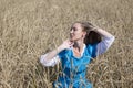 Eautiful woman in a blue long dress in the field of ripe cereals