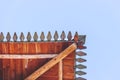 The eaves of house on the blue sky background. The eaves of the wooden roof of the ancient tower of the fortress.