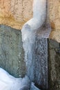 An eavestrough covered in ice and spring runoff water