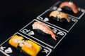 Ebi nigiri between Unagi and Tomago. Hand drawn Poker cards, Japanese sushi nigiri with black rice and shrimp in focus on chalkboa