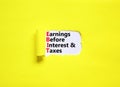 EBIT symbol. Concept words EBIT earnings before interest and taxes on white paper on beautiful yellow background. Business EBIT