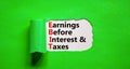 EBIT symbol. Concept words EBIT earnings before interest and taxes on white paper on beautiful green background. Business EBIT