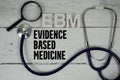 EBM Evidence-based Medicine text with Stethoscope on wooden background Royalty Free Stock Photo