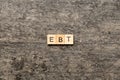 EBT word written on wood block. Abbreviation Earnings Before Taxes text on cement table for your desing, concept Royalty Free Stock Photo