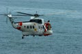An ec225 Super Puma helicopter flies over the sea near the coast