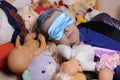 Eccentric man sleeping with mask , lots of dolls and stuffed animals