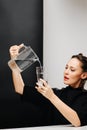 Eccentric woman pouring water in a glass from a jug, holding on a head height Royalty Free Stock Photo