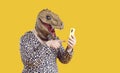 Ecentric funny fat man in dinosaur mask uses mobile applications and communicates on social networks Royalty Free Stock Photo