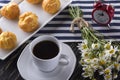 Eclair, coffee cup, alarm clock and charmomile. Royalty Free Stock Photo
