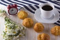 Eclair, coffee cup, alarm clock and charmomile. Royalty Free Stock Photo