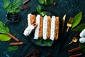 Eclair with cream. Creamy dessert on a black stone plate. Top view. Rustic style